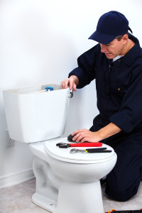 A plumber fixing a toilet